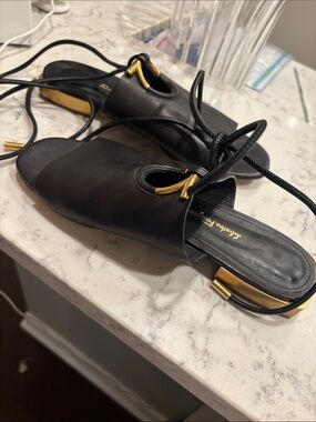 Ferragamo: Black Leather Lace-Up Flat Sandals with Gold Accent heel